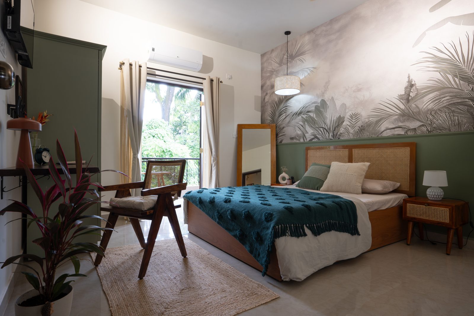 Olive green bedroom with rattan chair and leafy balcony view at Birdsong Nature Stylish