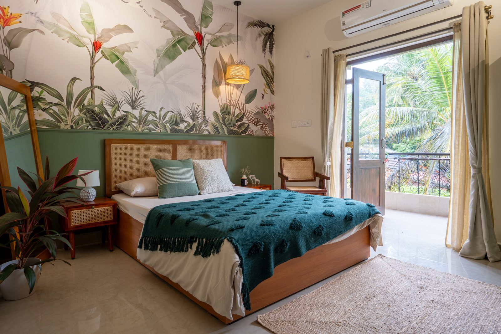 Bedroom with tropical leaf mural and teal bedspread at The Rainforest Suite