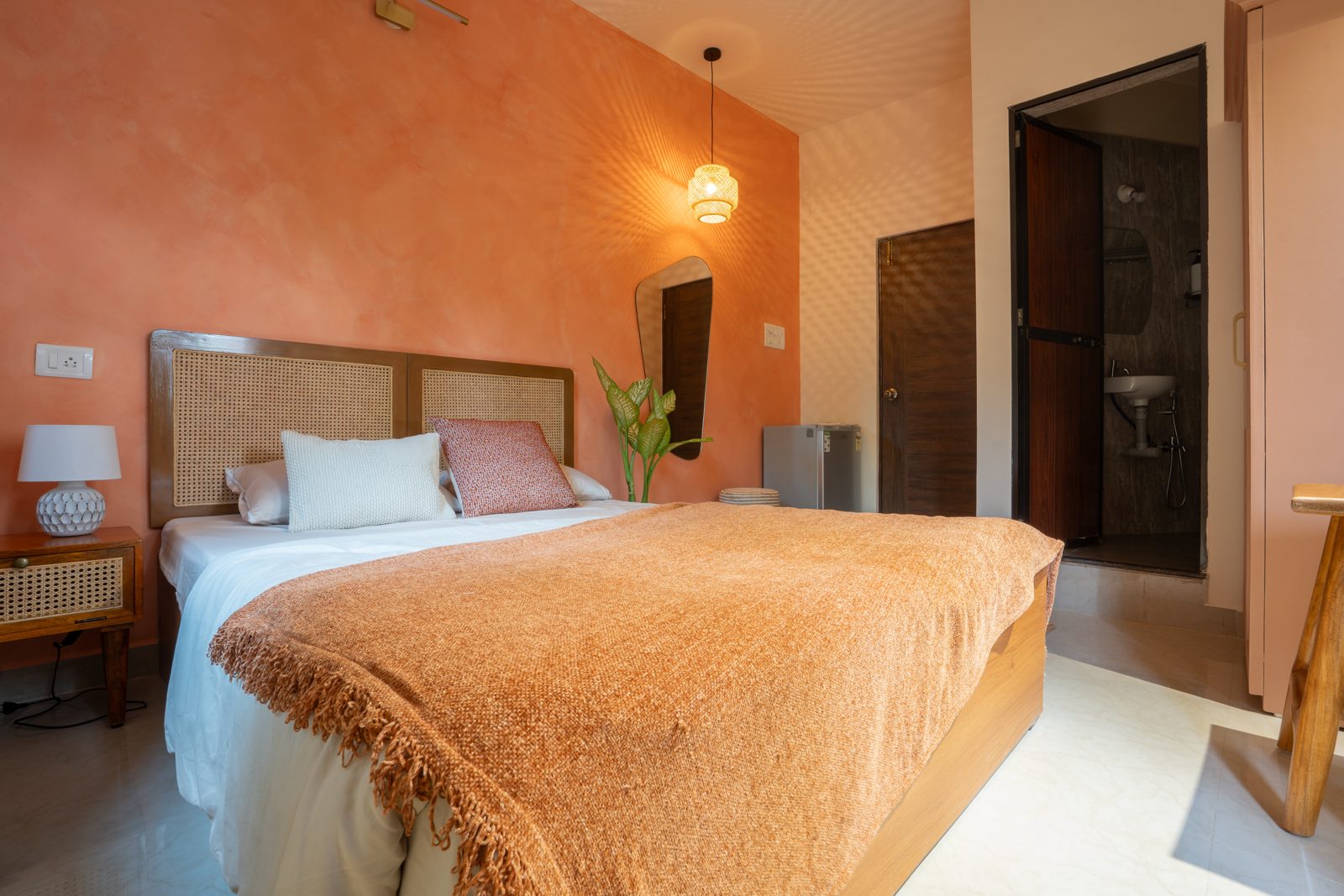 Terracotta-walled bedroom with rattan headboard at The Stylish Boho